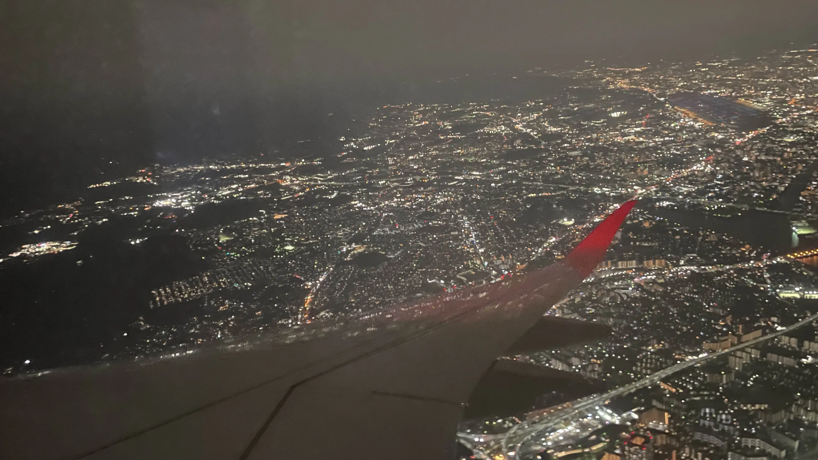 飛行機から撮った写真。福岡の市街地の夜景を見下ろしている。